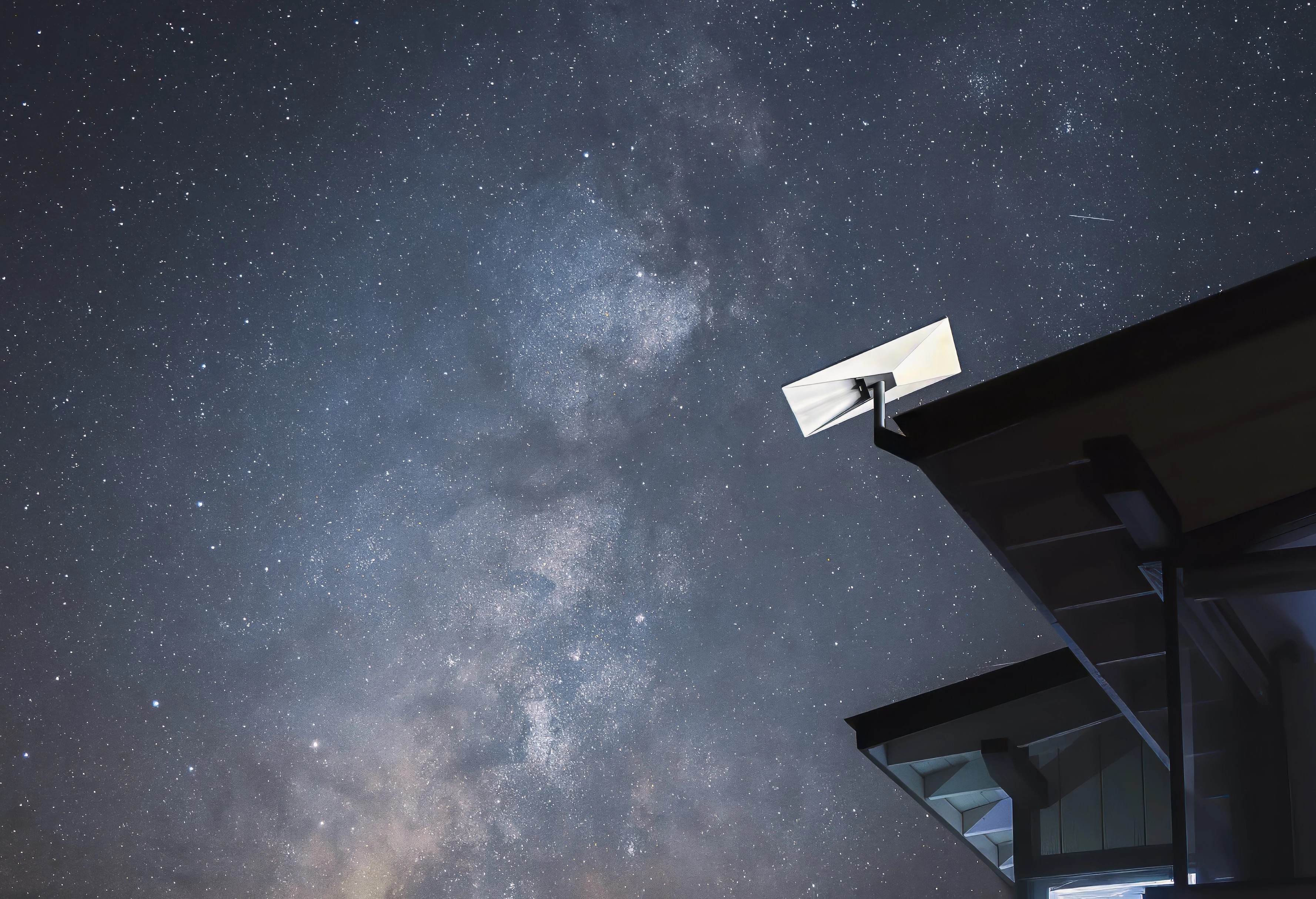 Antena Starlink montada en un edificio bajo un cielo estrellado